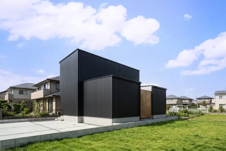 ブラックのガルバリウムを使用した、シンプルでスタイリッシュな外観。植栽と斜め壁のポーチがアクセント